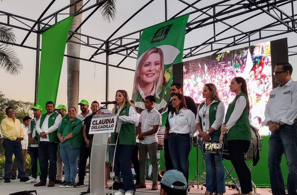 Personas vestidas de verde en un mitin político.