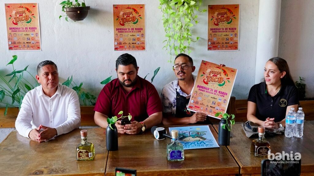 Personas en una mesa anunciando la Feria del Taco en Puerto Vallarta.