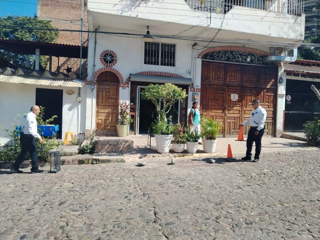 a man standing on a cobblestone street with a couple of people