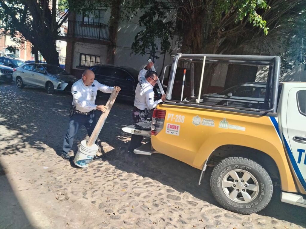 a man holding a pole next to a yellow truck