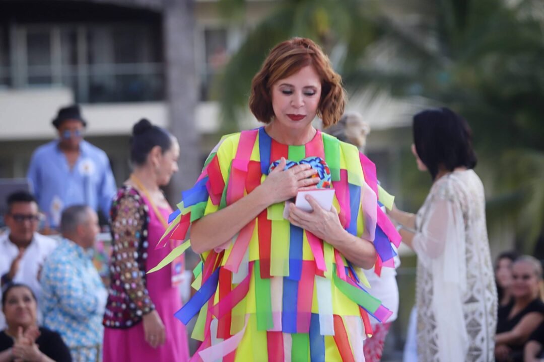 Una mujer vestida de colores, desfila en el Sunset Fashion Show en Puerto Vallarta.