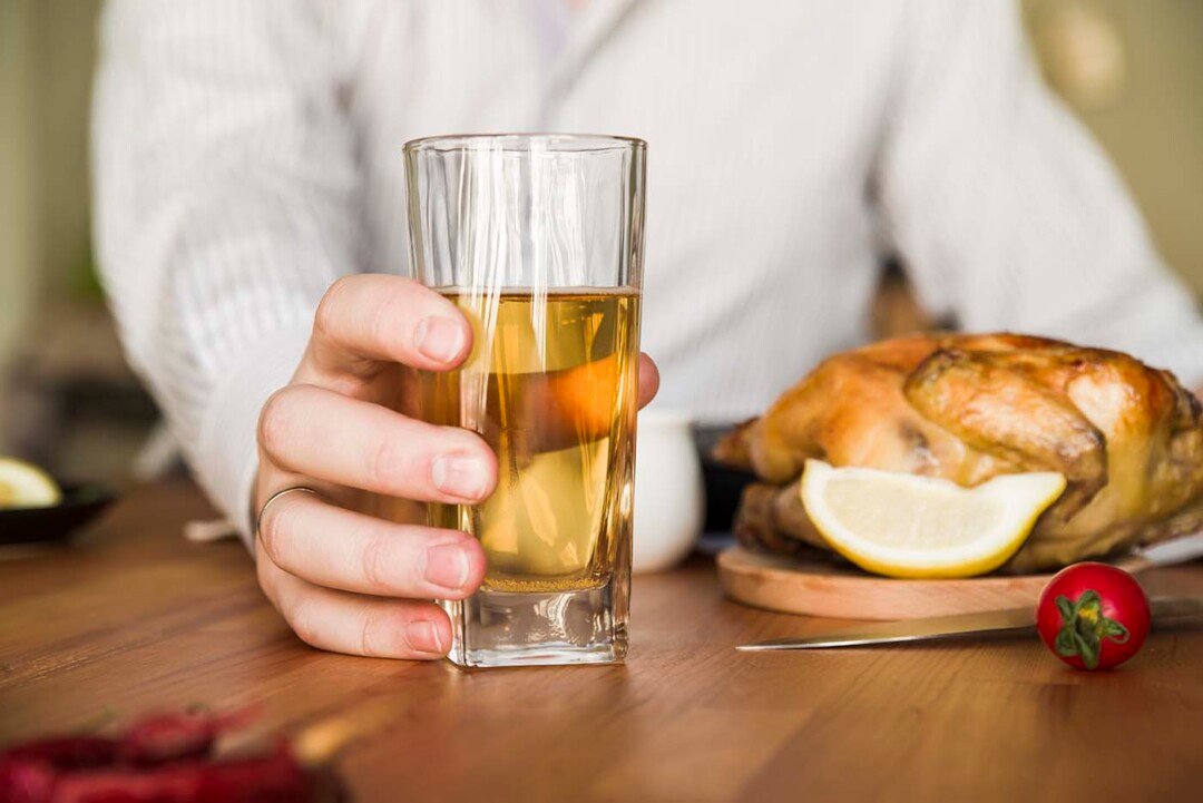 Mezcal de Pechuga: el espirituoso ritual que México destila con alma 2 close up man s hand holding glass beer with whole roasted chicken table